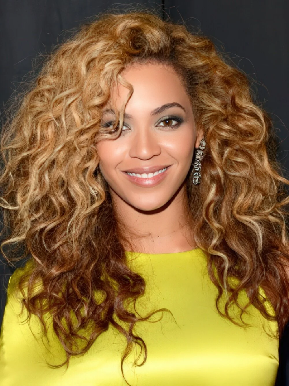 Long honey-bronde curls with a side part.