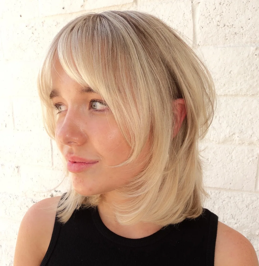 Photo showing blonde Bob With Curtain Bangs, with the hairstyle clearly visible.