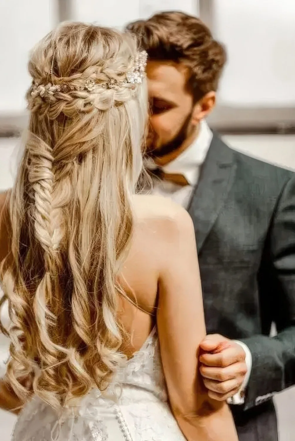 Boho half updo with a double braided halo, a fishtail braid, waves down and a delicate embellished hair vine.