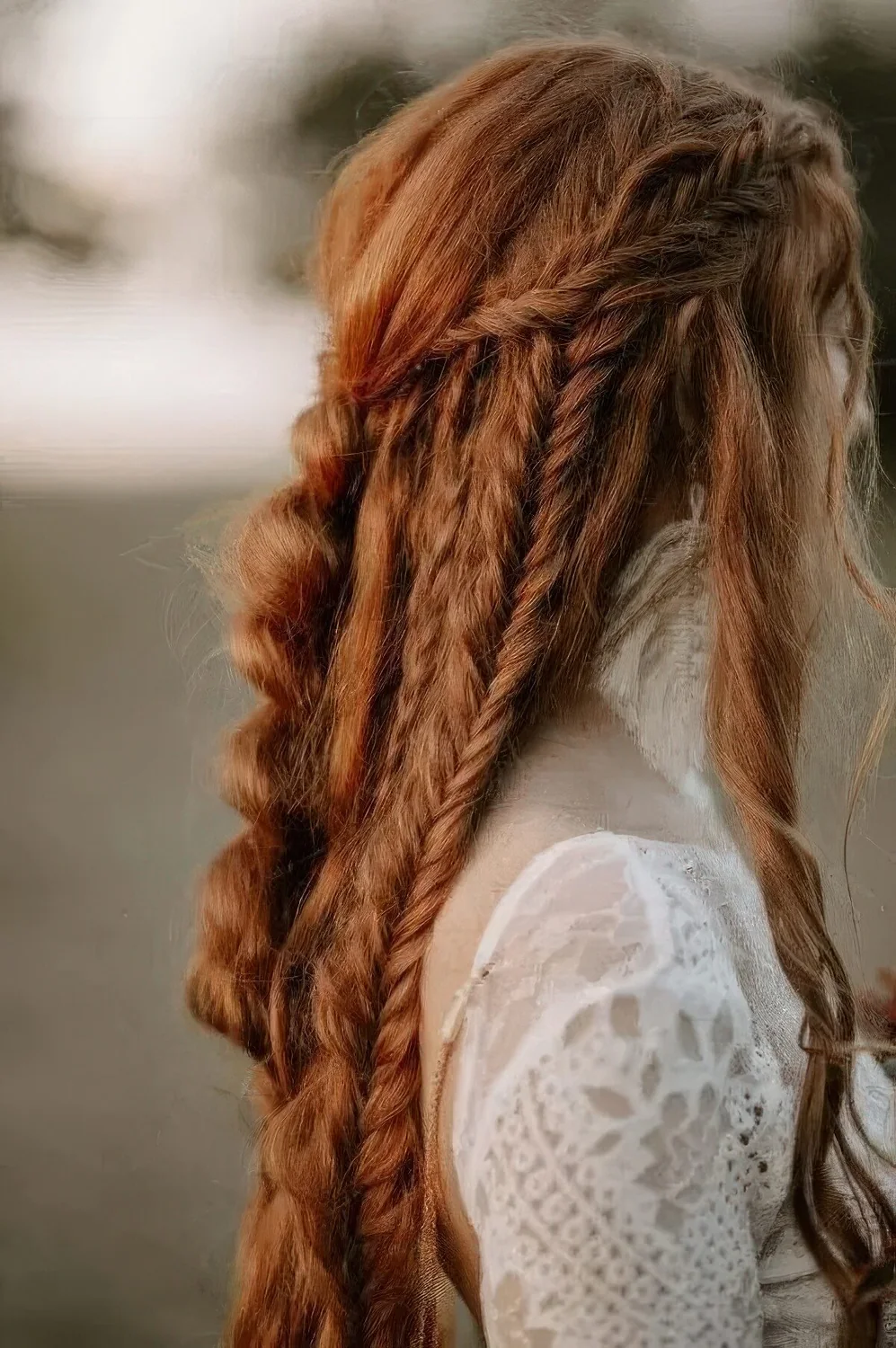 Boho ginger hairstyle with braids all over and a bump on top.