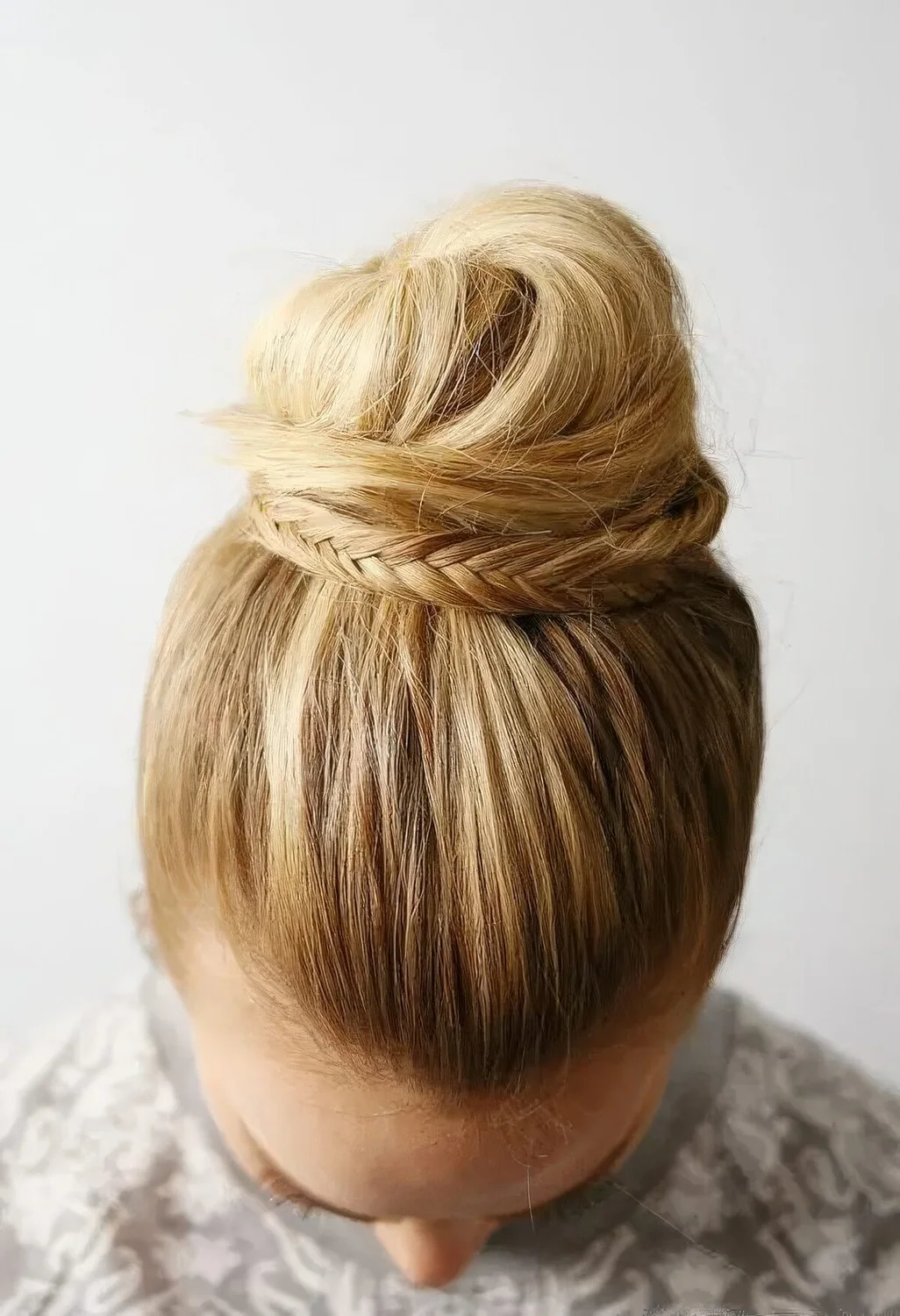 Photo showing top knot with a fishtail braid, with the hairstyle clearly visible.
