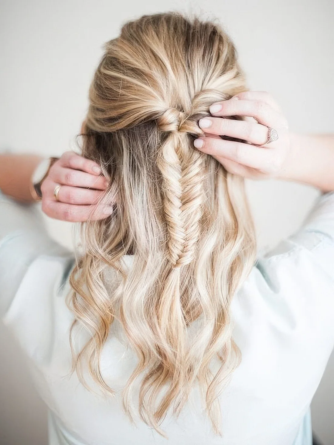 Boho half updo with a bump on top, a fishtail braid and waves down.