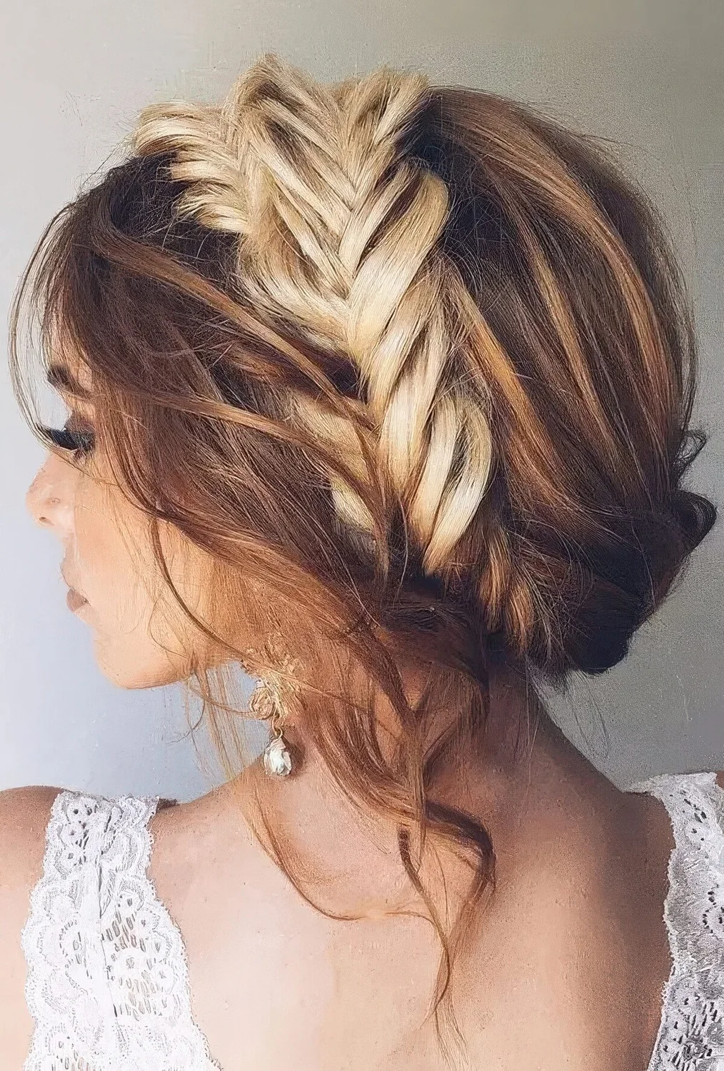 Messy and wavy updo with a large fishtail braid in the center and locks down.