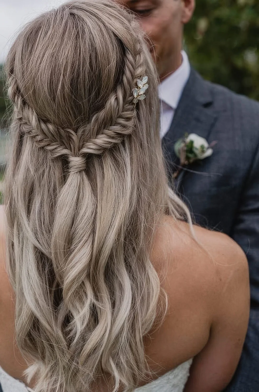 Wavy half updo with braids and a tiny embellished hairpiece.