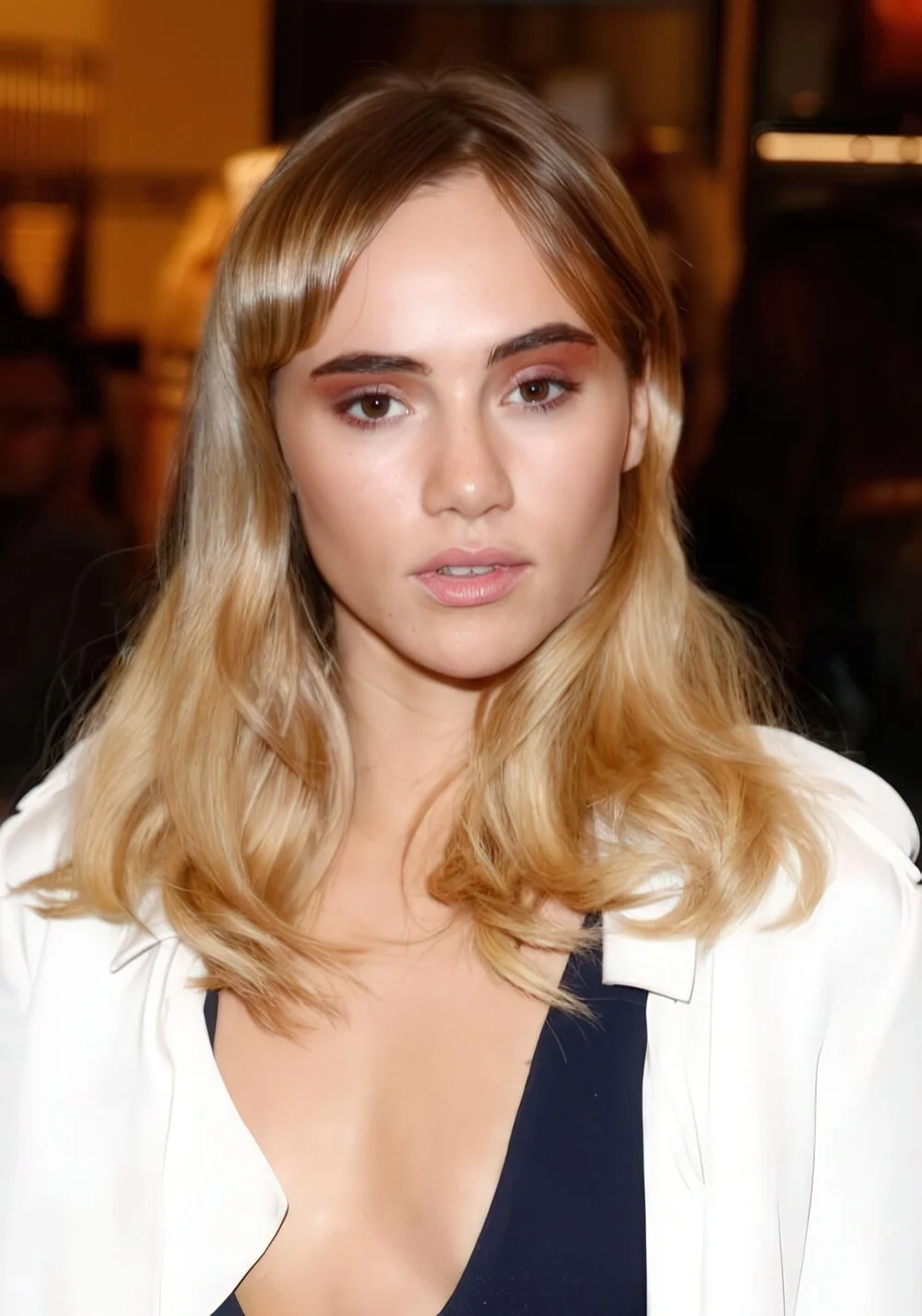 Long blonde waves with curtain bangs.