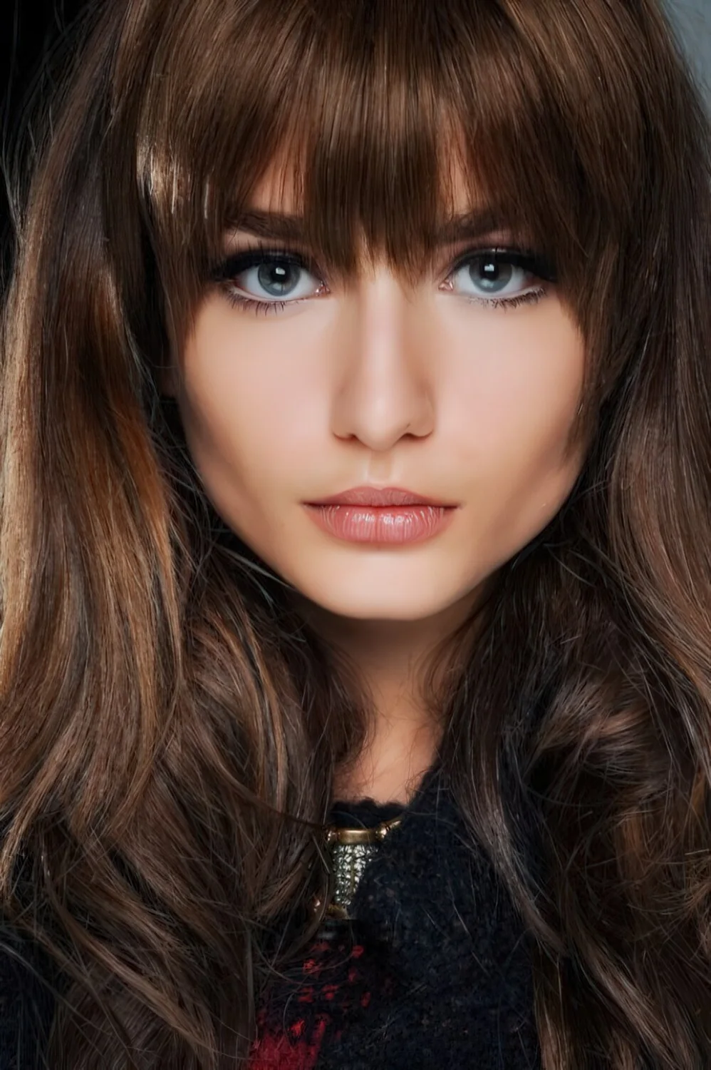 Long brunette waves with blunt full bangs.