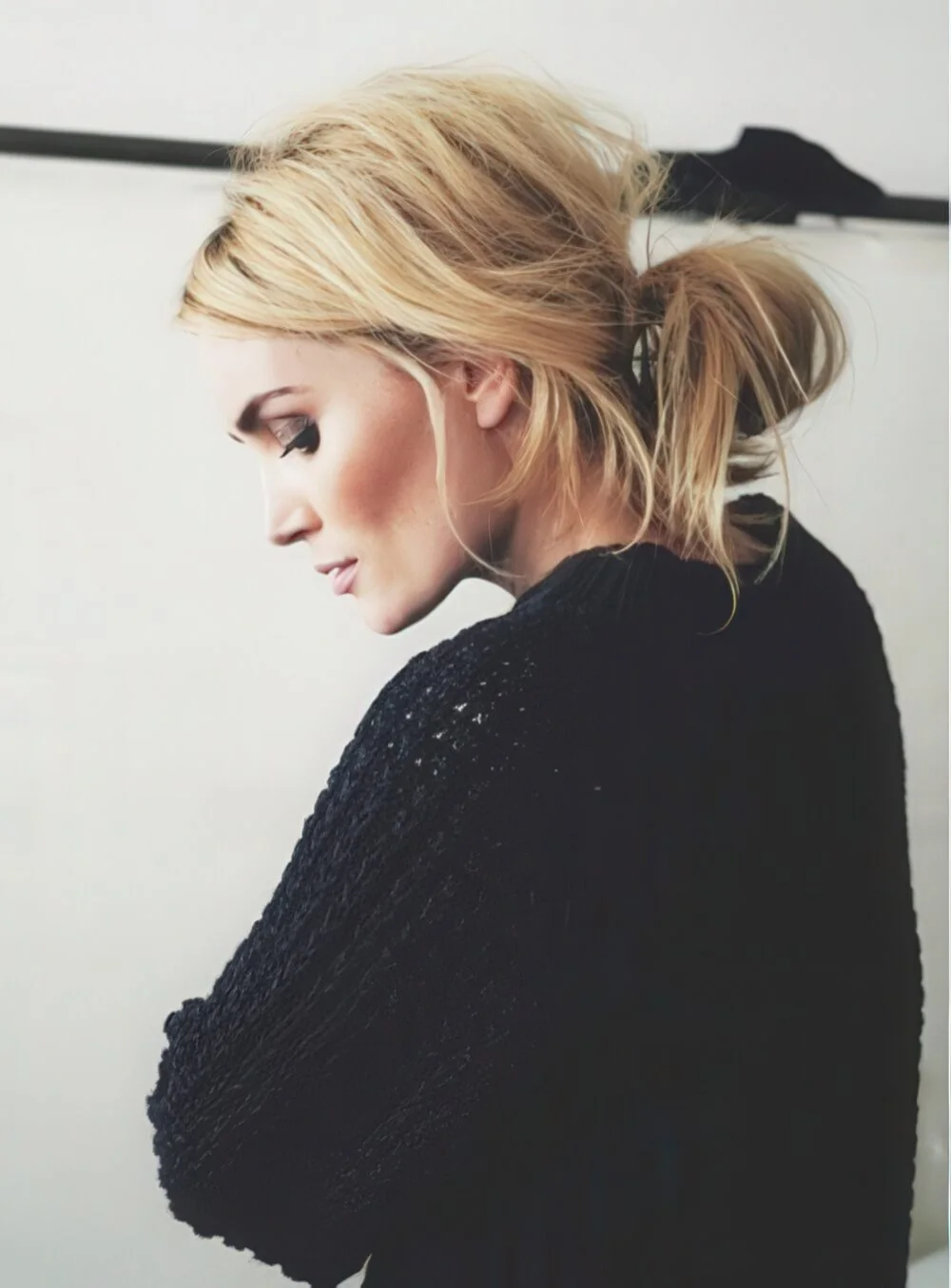 Messy blonde ponytail with loose front pieces.