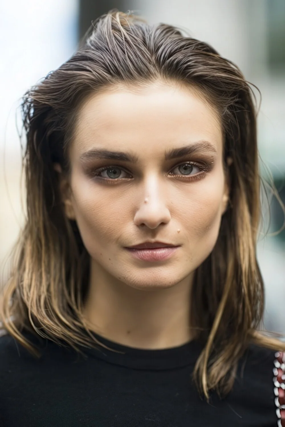 Wet-look brunette hair swept back from the face.