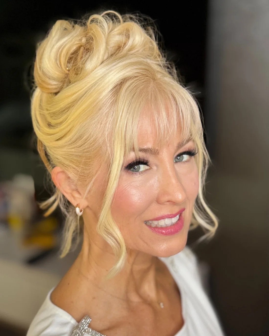 Soft bangs with a polished swept updo.