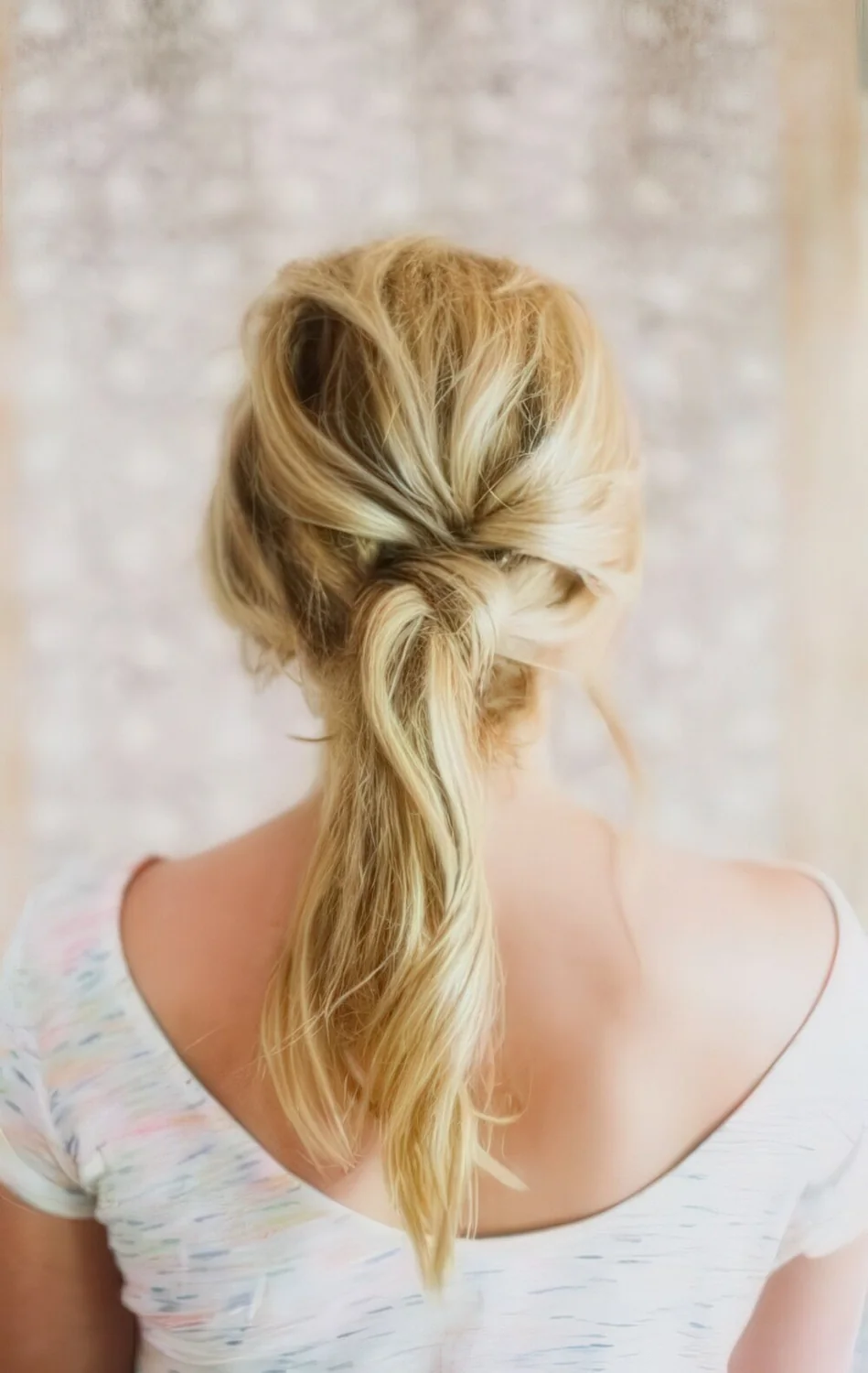 Photo showing twisted blonde low ponytail, with the hairstyle clearly visible.