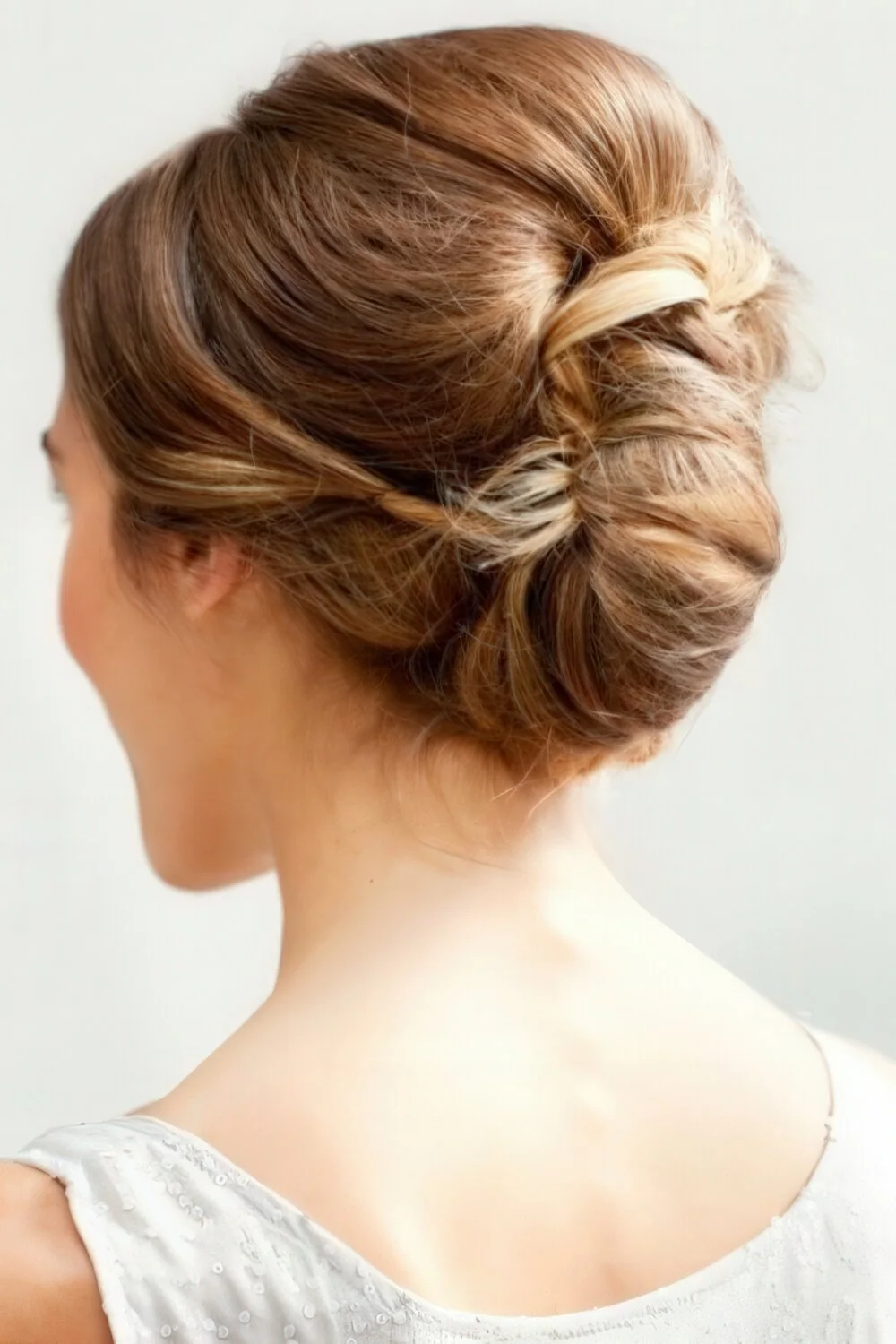 Photo showing polished brunette French twist, with the hairstyle clearly visible.