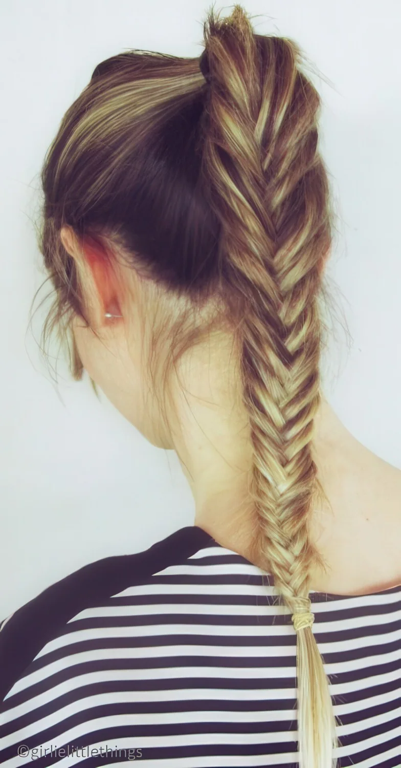 Photo showing long brunette fishtail braid, with the hairstyle clearly visible.