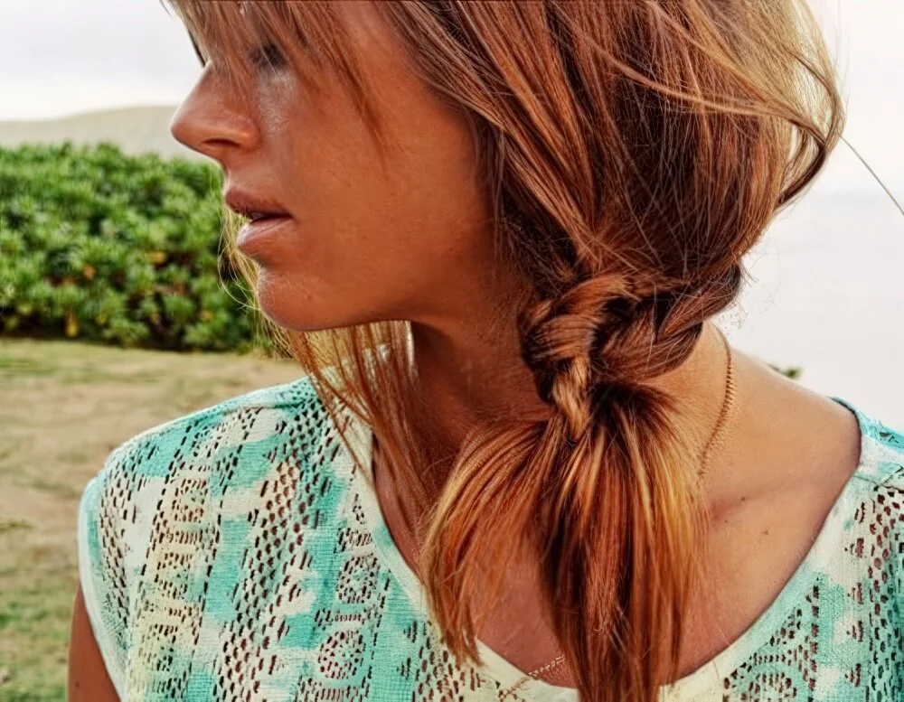 Loose low red ponytail with side-swept fringe.