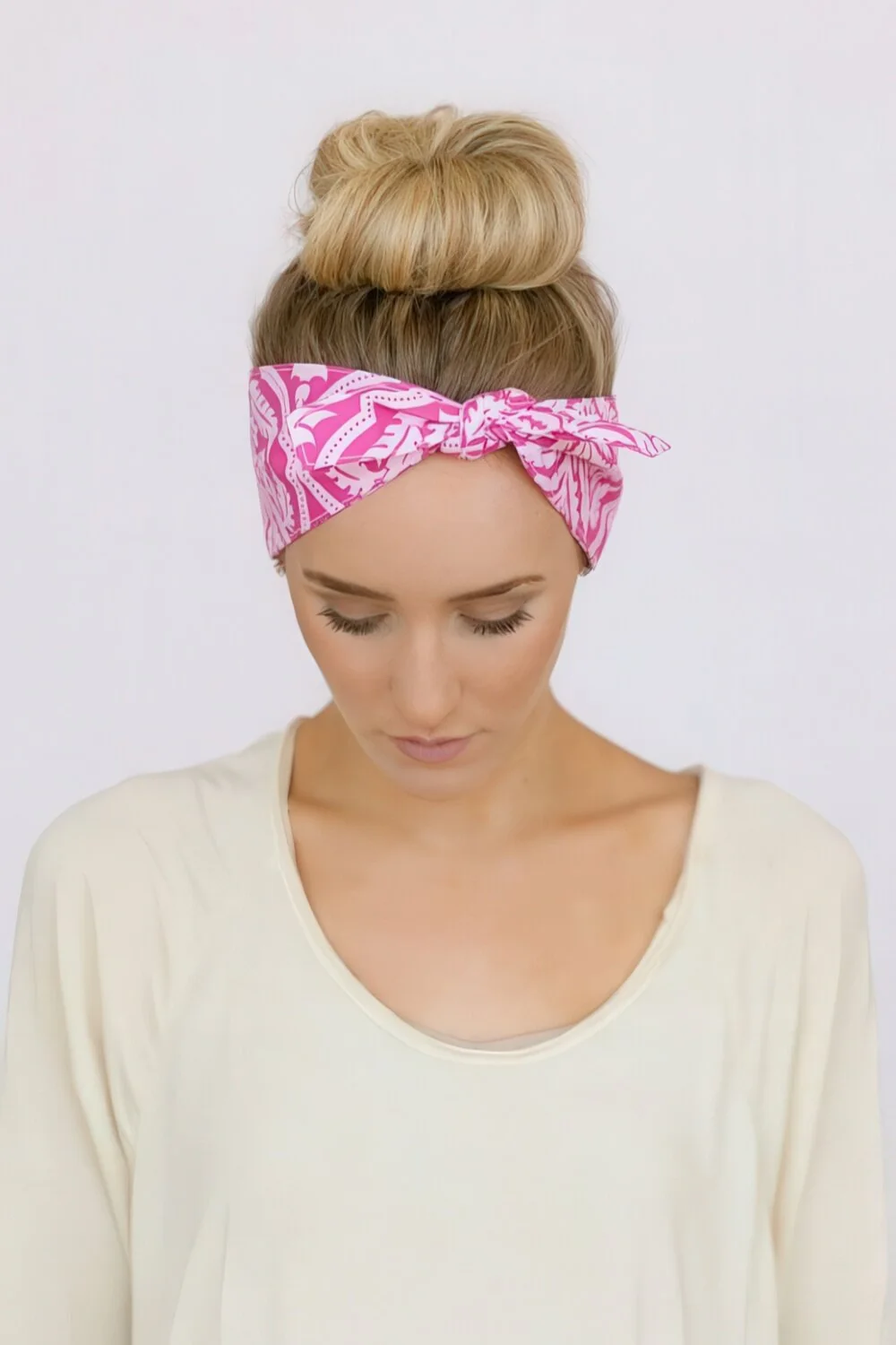 High bun wrapped with a pink bandana.