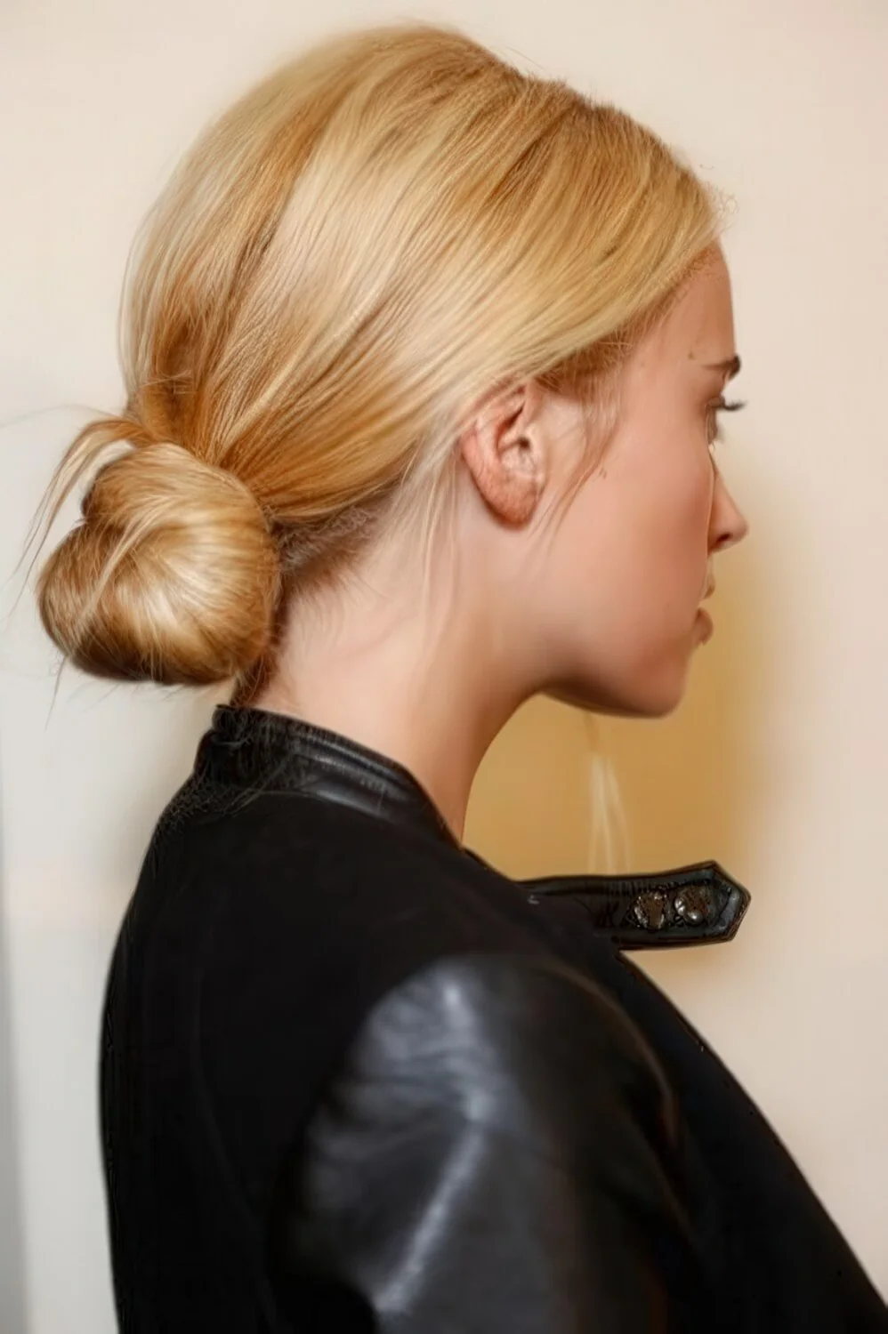 Photo showing sleek blonde low bun, with the hairstyle clearly visible.