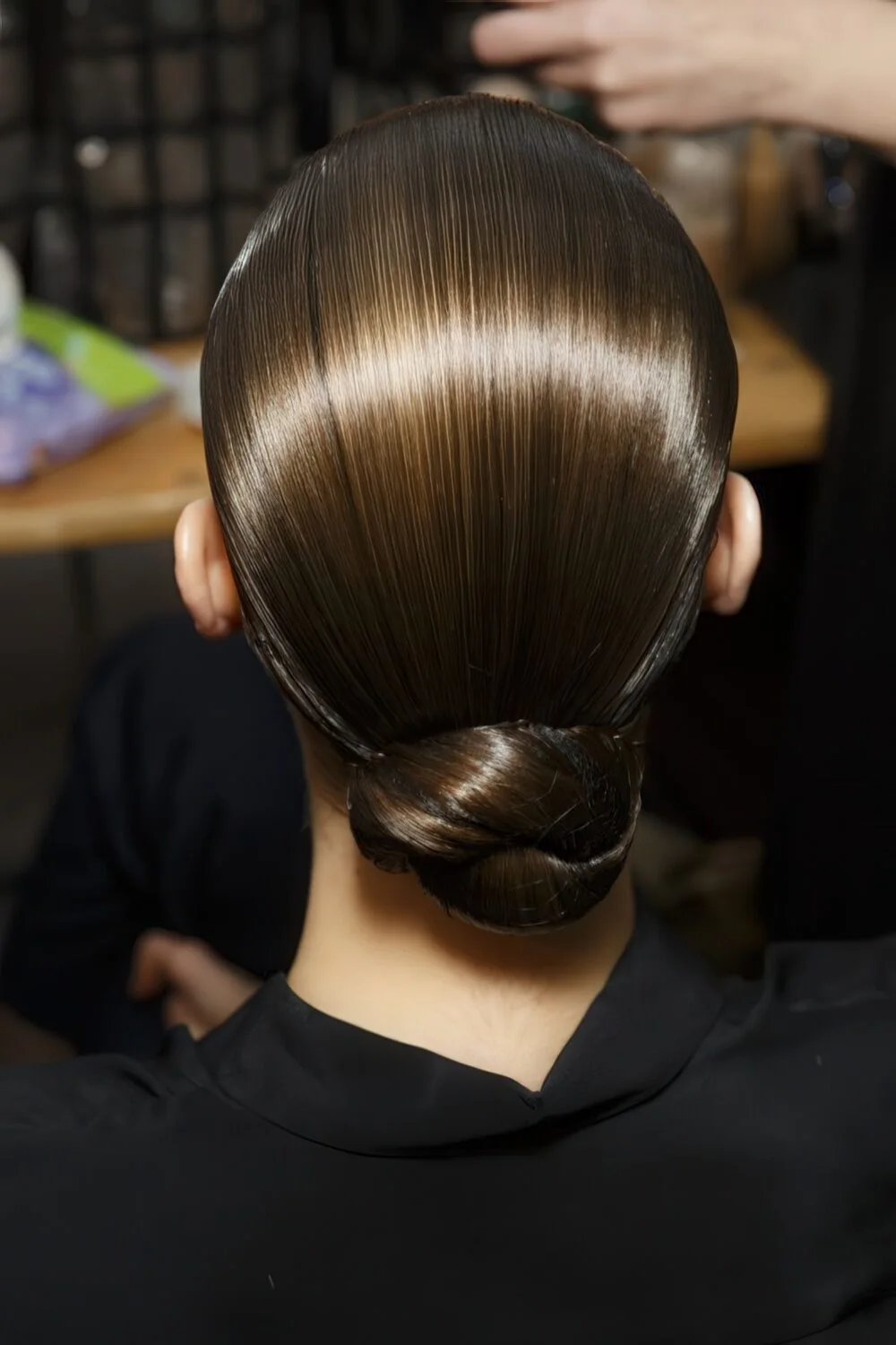 Photo showing glossy black low knot, with the hairstyle clearly visible.