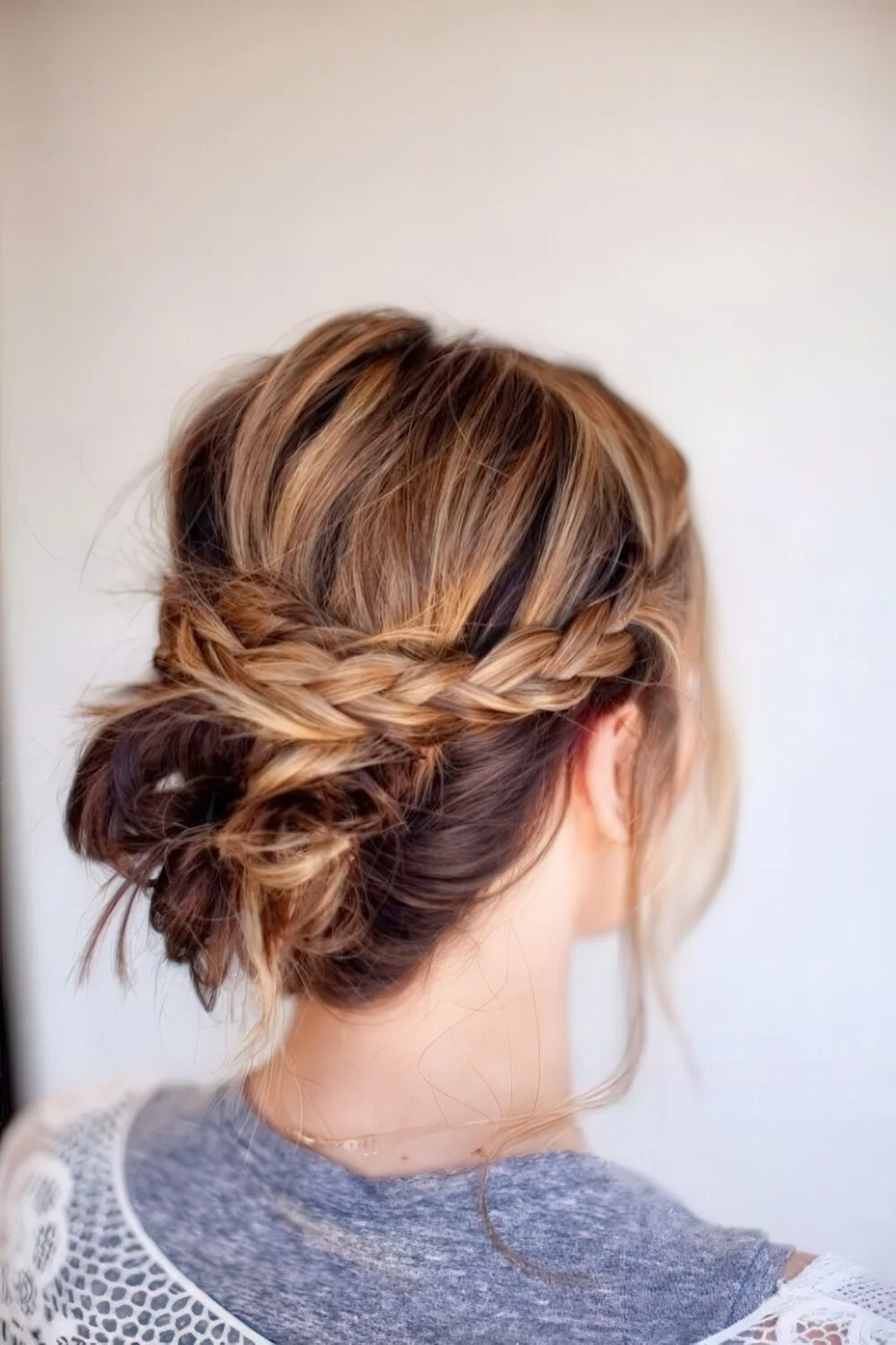 Photo showing braided brunette low updo, with the hairstyle clearly visible.