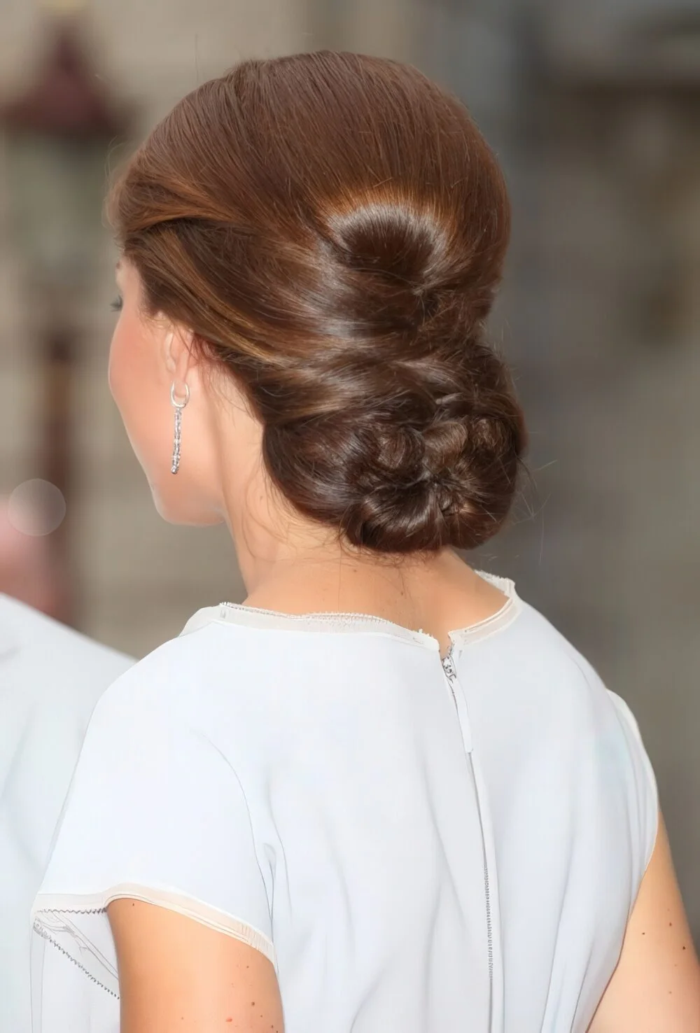 Photo showing twisted brunette low bun, with the hairstyle clearly visible.