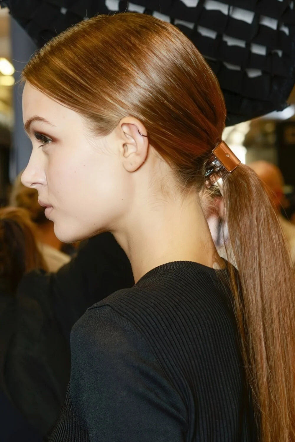 Photo showing sleek copper low ponytail, with the hairstyle clearly visible.