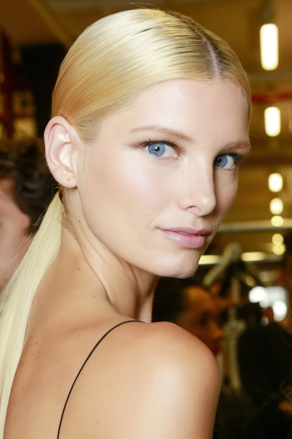 Photo showing sleek blonde low ponytail, with the hairstyle clearly visible.
