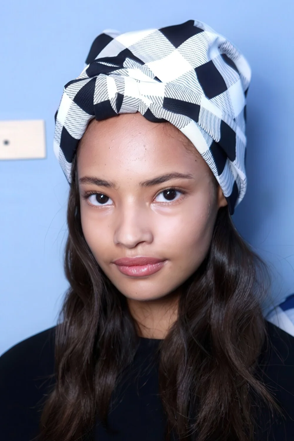 Long dark waves with a knotted headscarf.