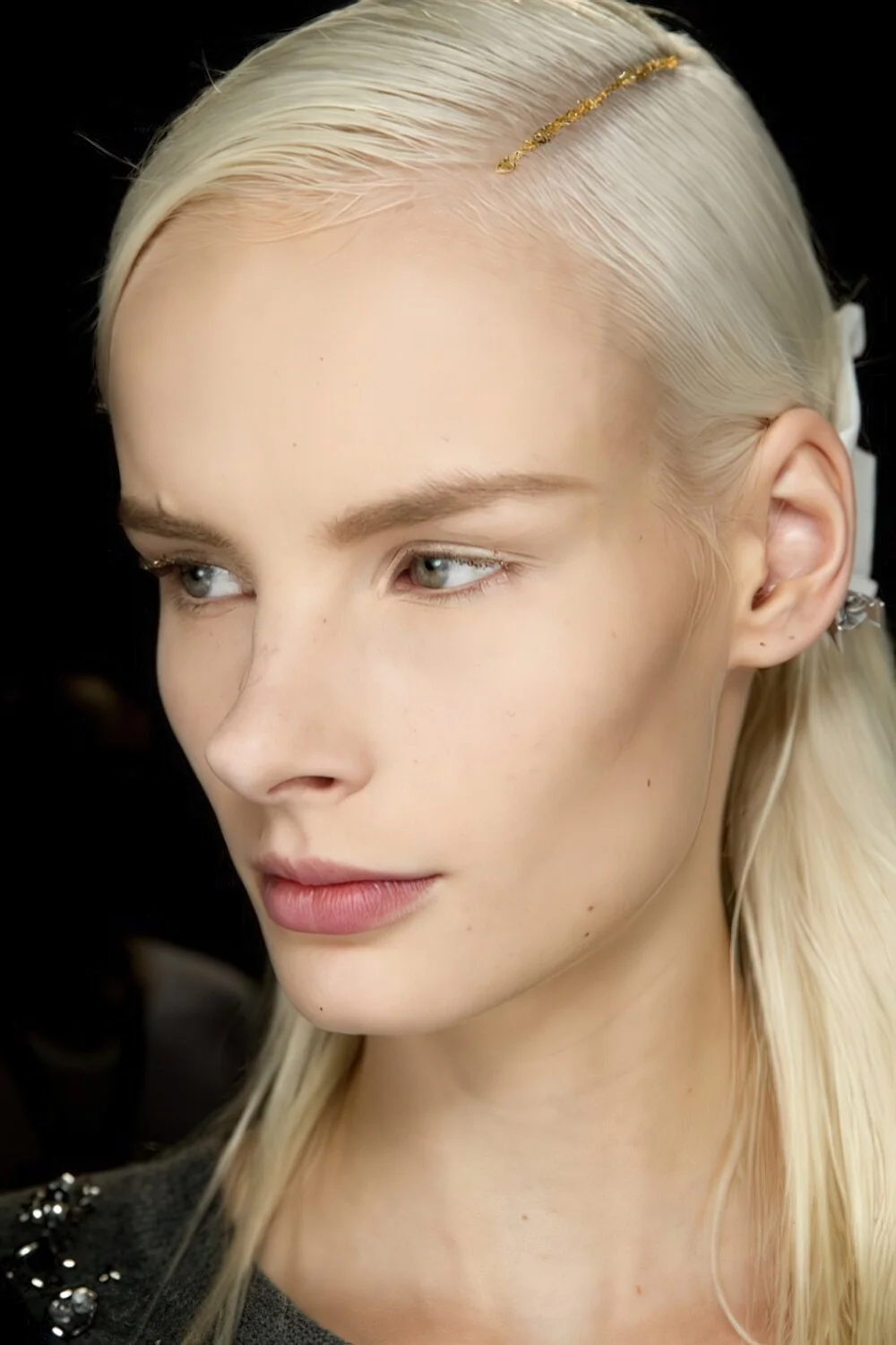 Sleek blonde side part with a slim hairpin.