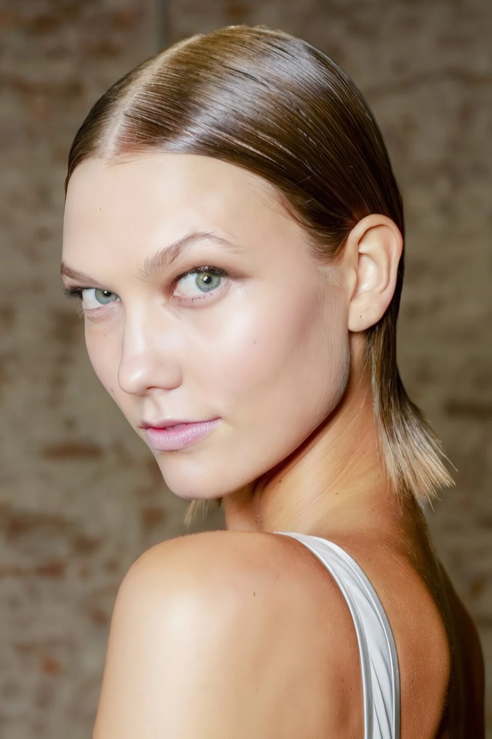 Photo showing slick brunette low ponytail, with the hairstyle clearly visible.