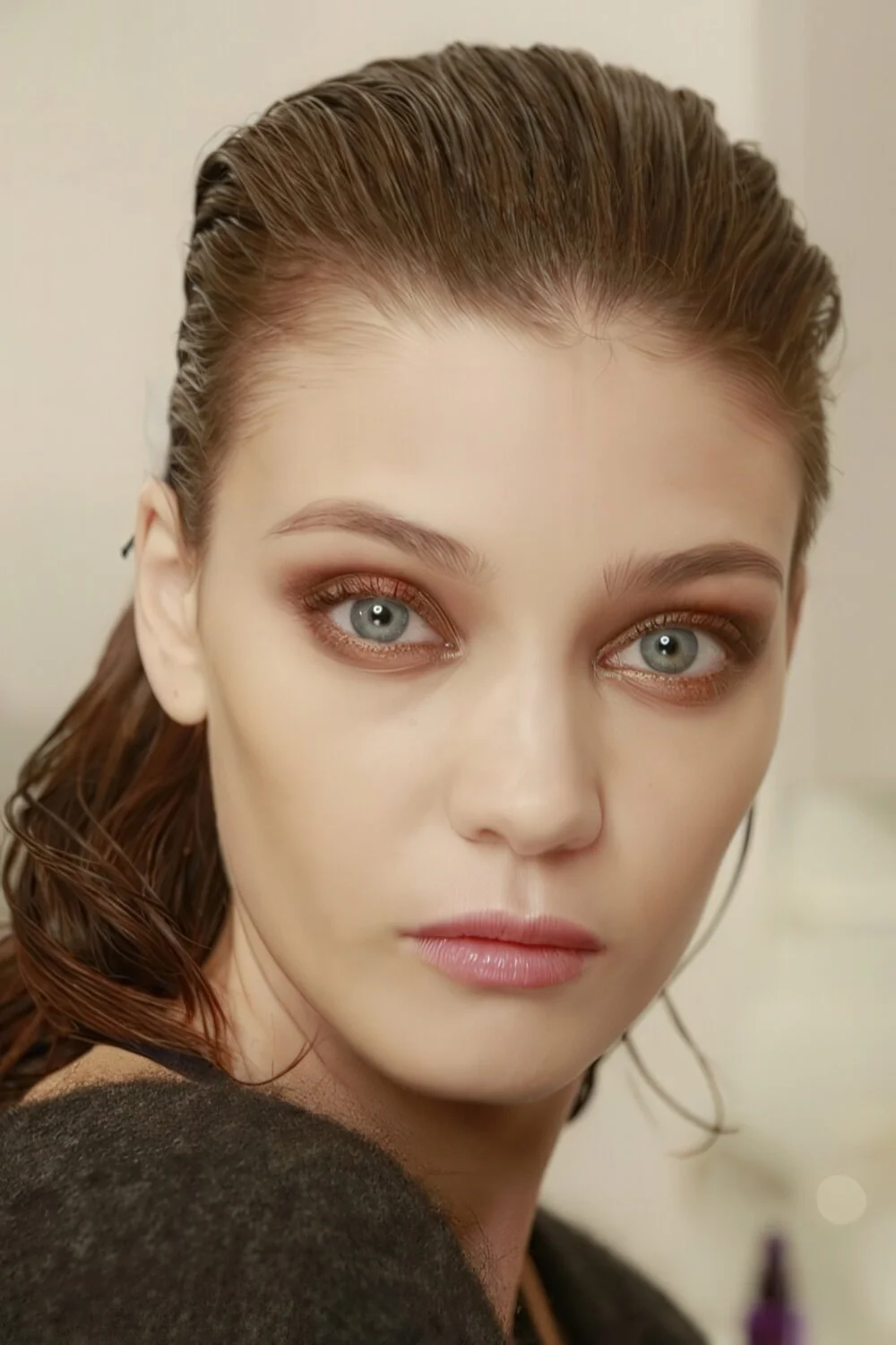 Photo showing wet-look brunette low ponytail, with the hairstyle clearly visible.