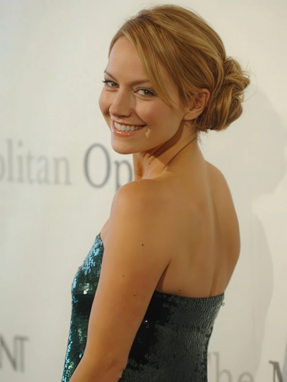 Photo showing smooth blonde low bun, with the hairstyle clearly visible.