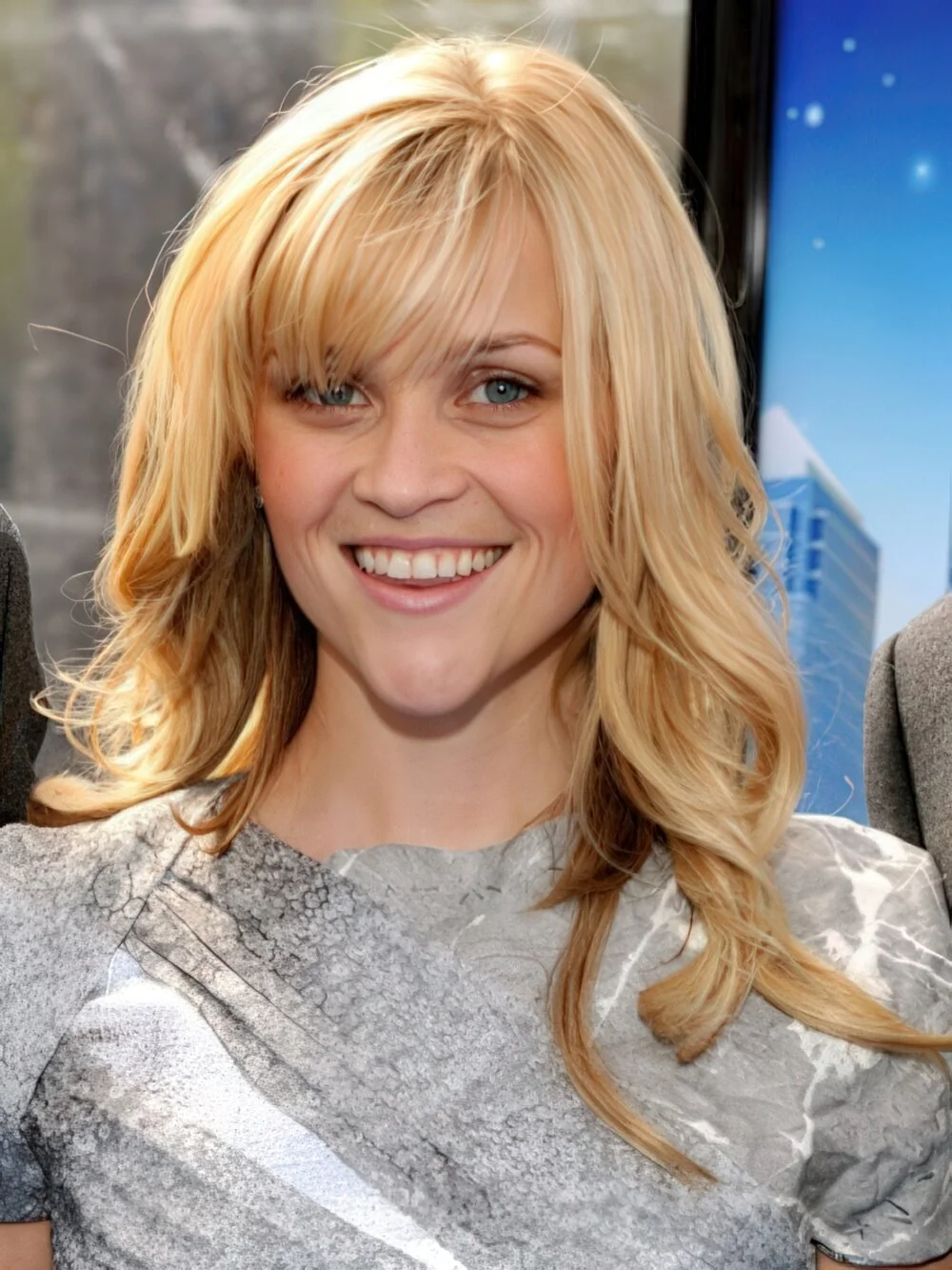 Long blonde layers with side-swept bangs.