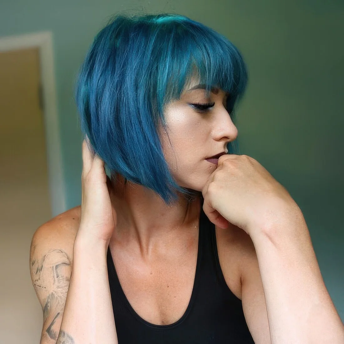 Teal angled chin-length bob with bangs.