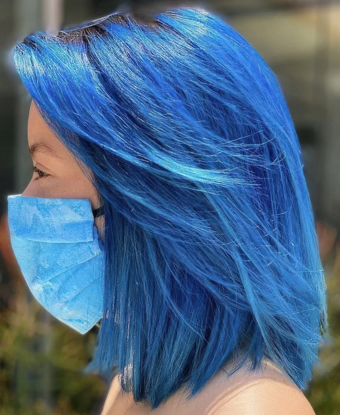 Blue long bob with side bangs and a darker root.