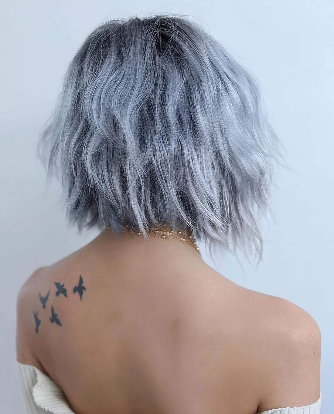 Very pale blue midi angled bob with a darker root and a bit of texture.