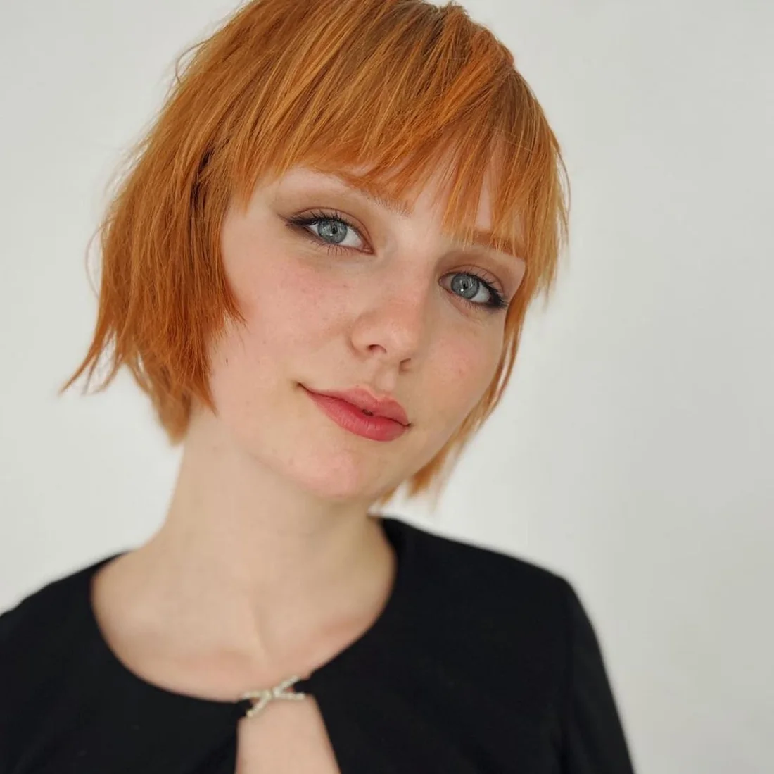 Copper mini bob with short blunt bangs.