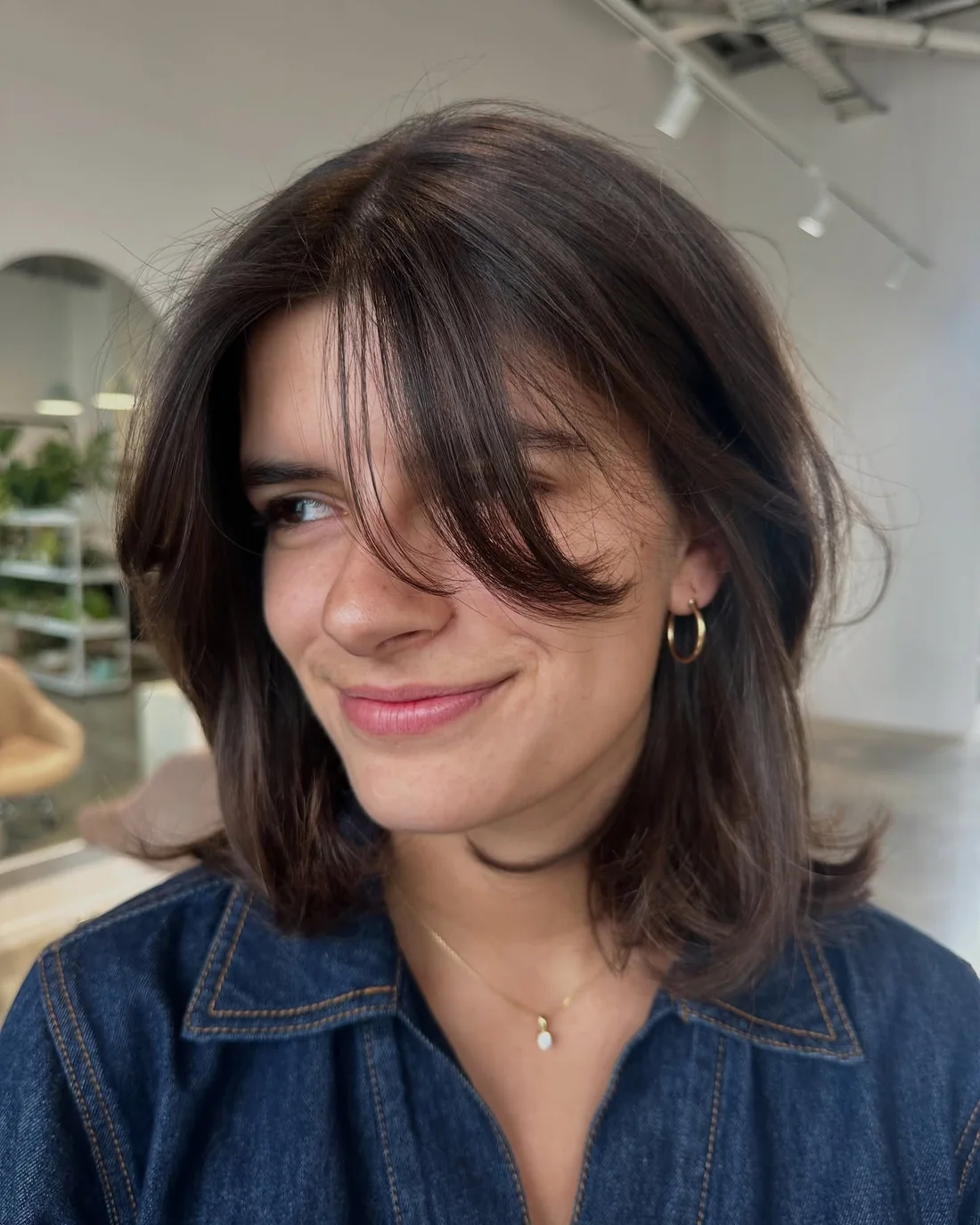 Shoulder-length dark lob with parted curtain fringe.