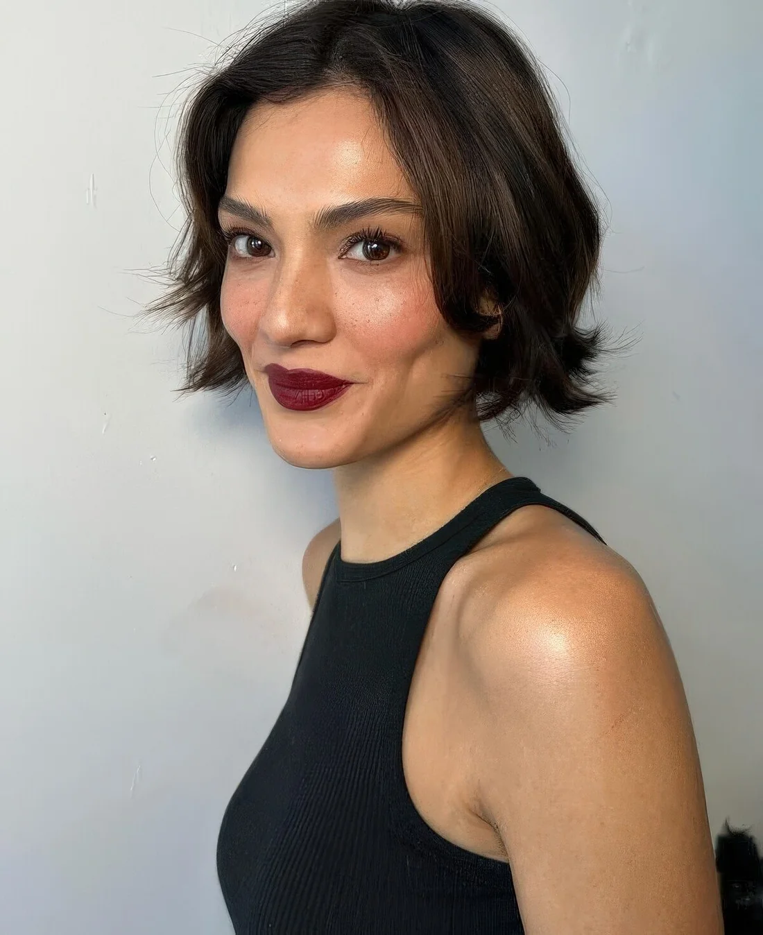 Messy 90s bob with feathered ends and curtain bangs.