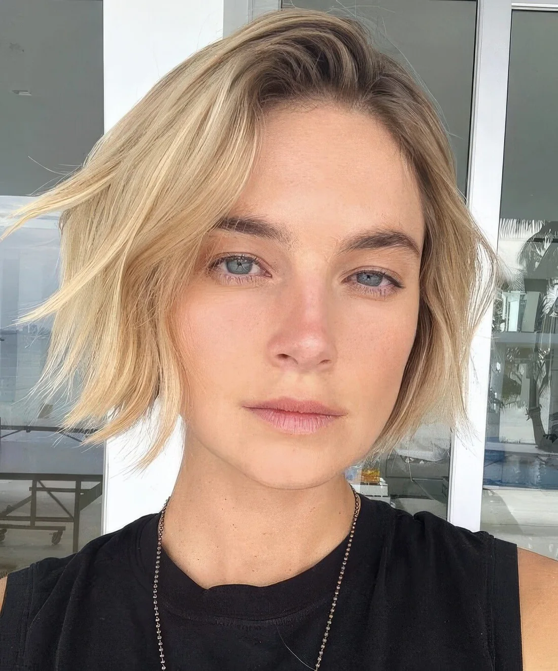 Messy wavy lip line blonde bob with a shadow root.