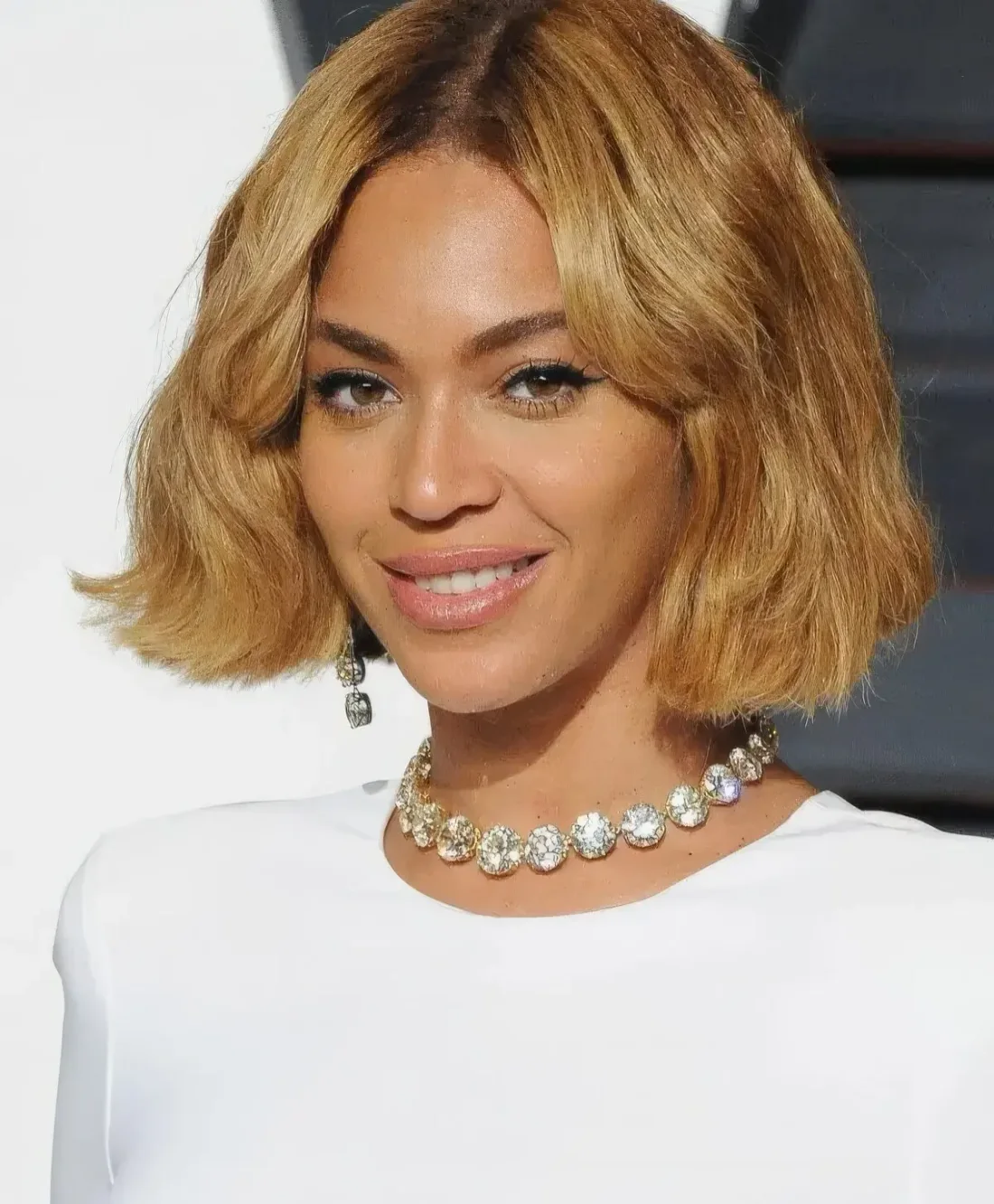 Bey’s chin-length bob shows off her thick hair and honey blonde color, and the bangs worn parted slightly off center soften the vibe created by the blunt ends.