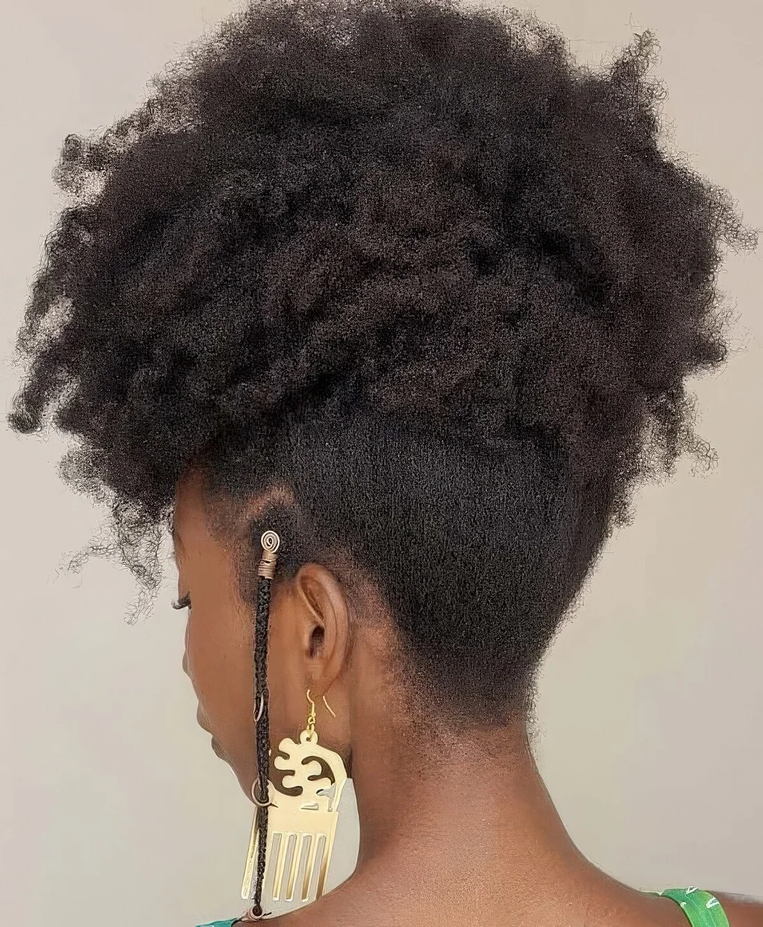 Natural updo with all of the hair swept up into an updo and there are loose braids at the front.
