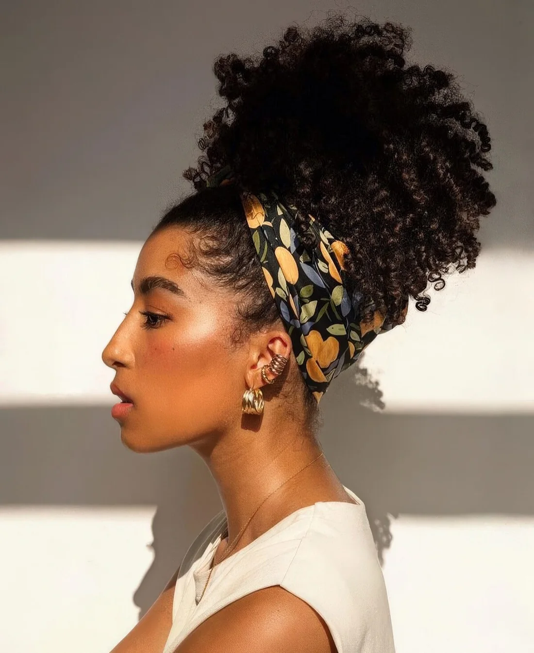 Wrap a scarf or a headwrap around and keep stray hairs from falling down to achieve a puff and headwrap combo.