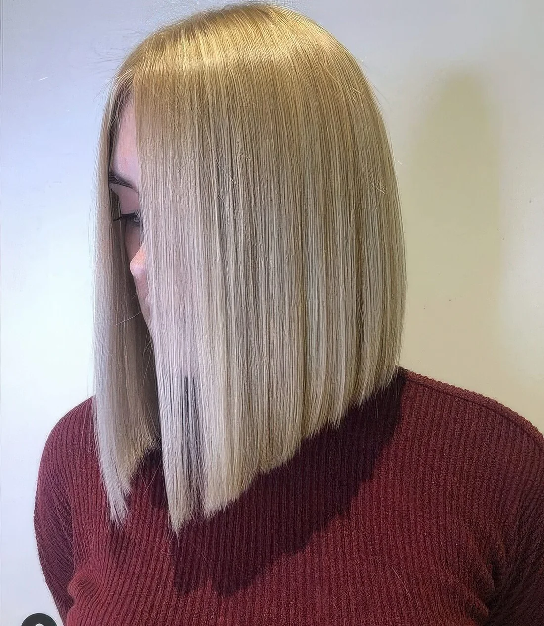 Chic creamy blonde A line long bob with side part.