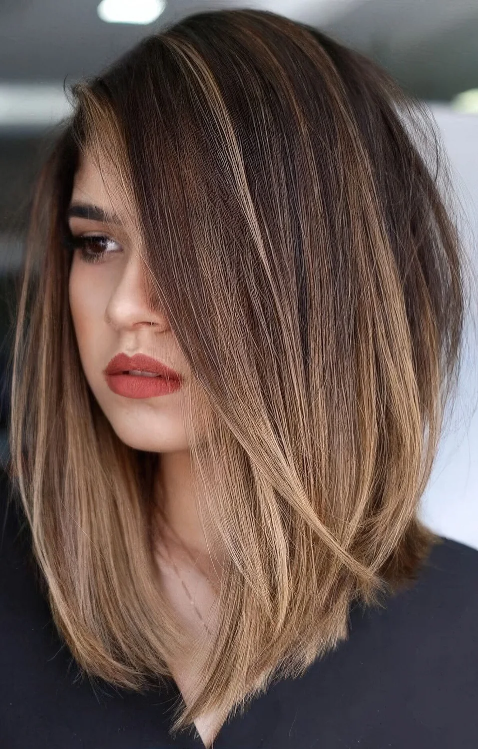 Jaw dropping dark brown A line long bob with caramel balayage and lowlights and much volume.