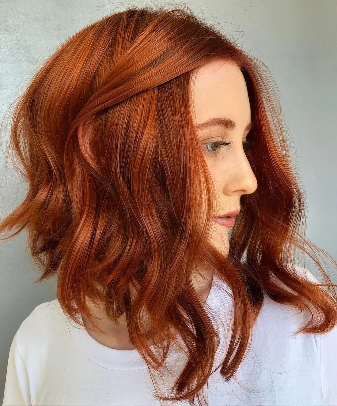 Long angled copper red bob with much volume and waves.