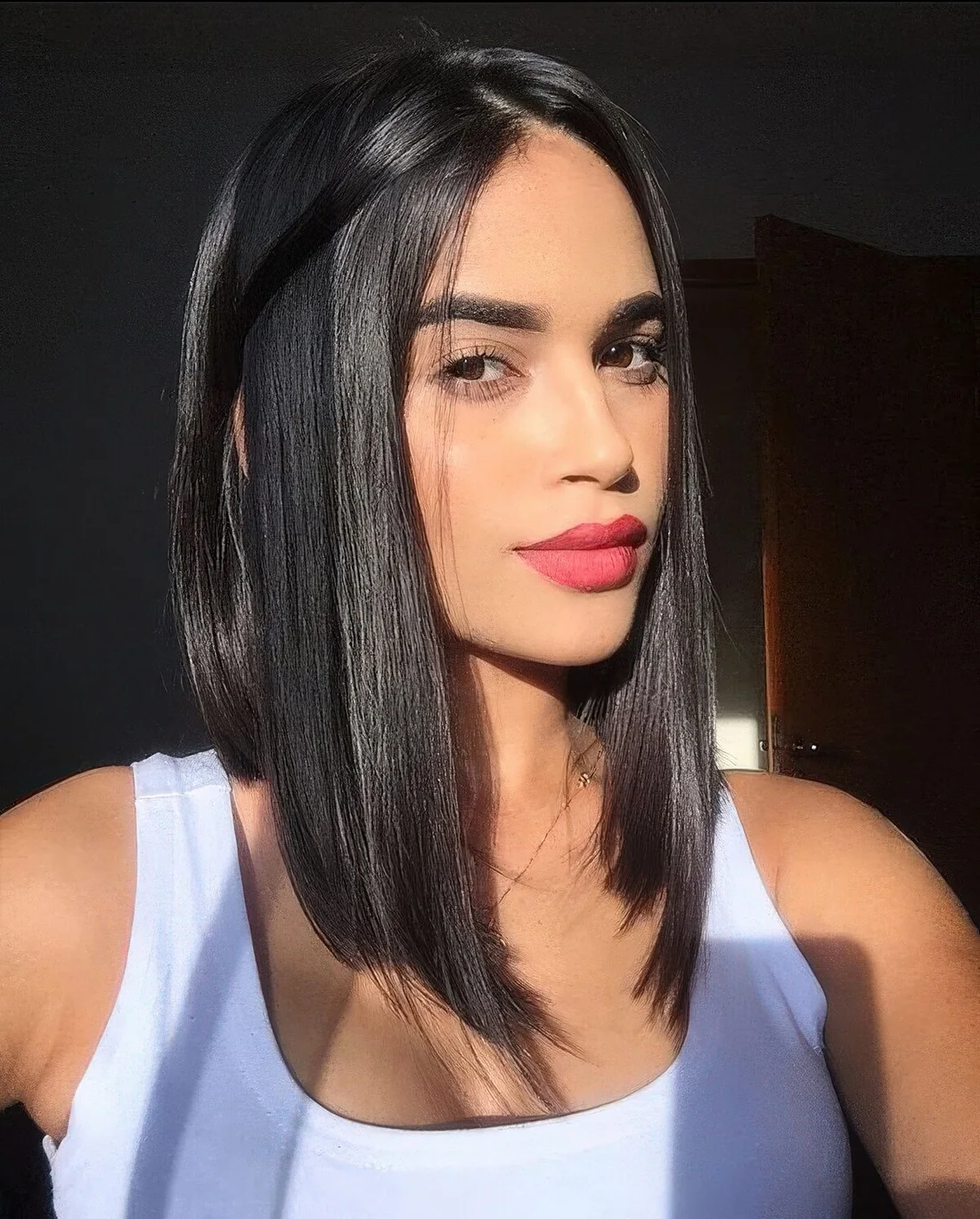 Glossy black hair styled in an A line bob, with much volume.