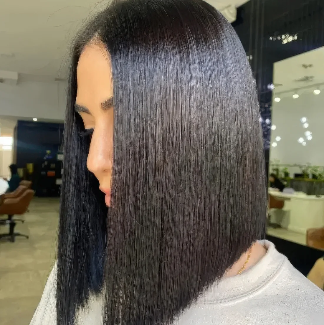 Dramatically sloped almost black glossy angled long bob.