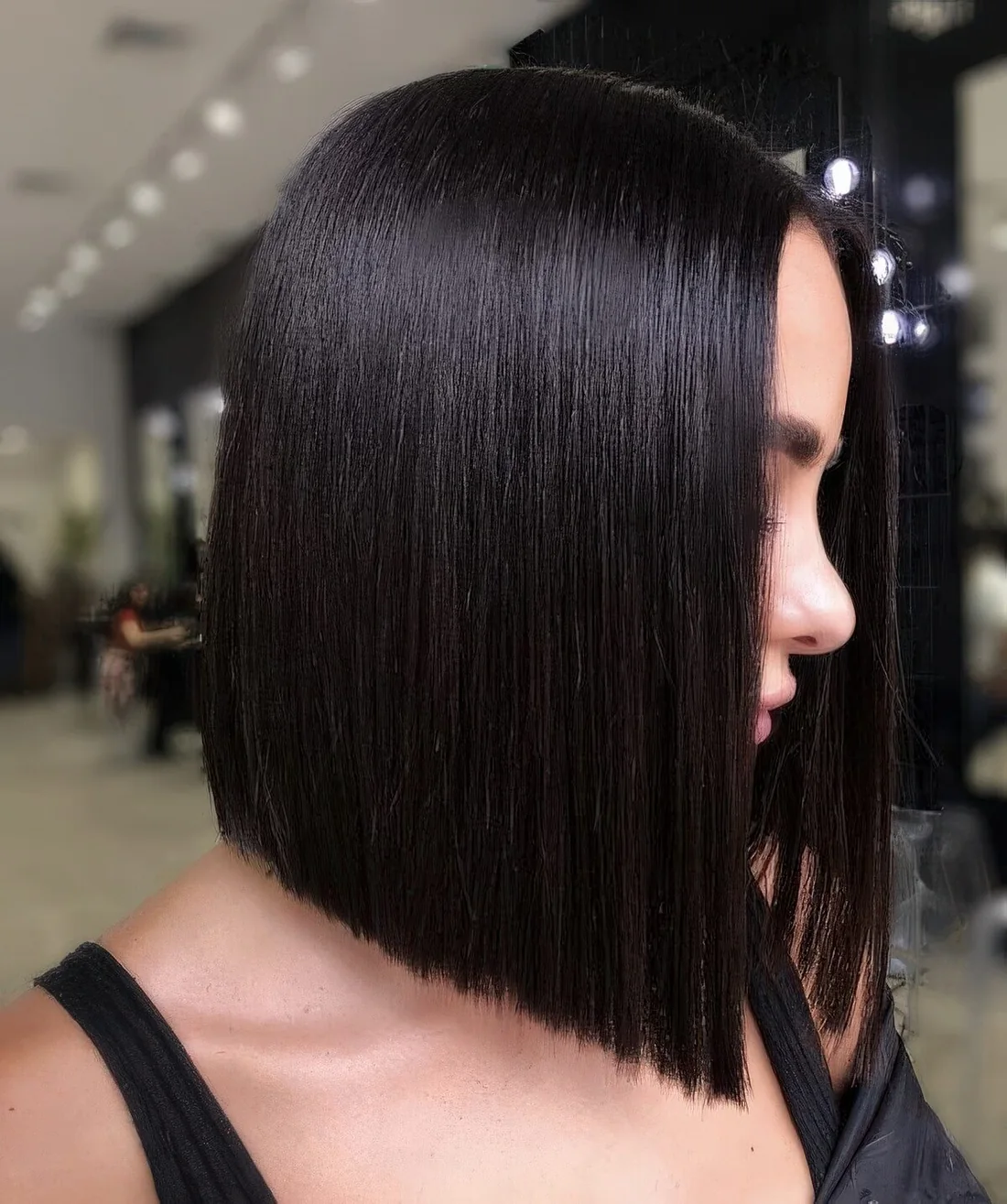 Sleek black angled bob with a shiny touch.