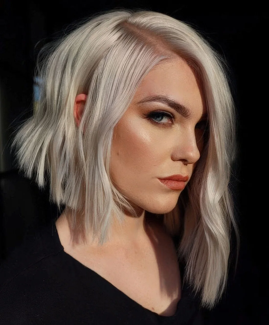 Platinum angled bob with side part and waves.