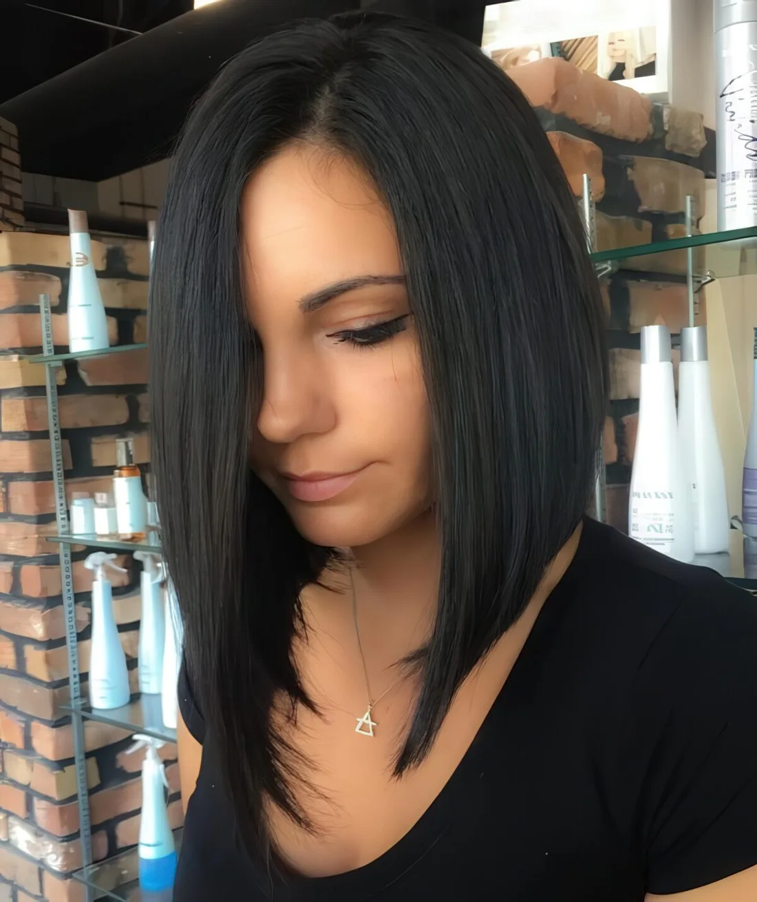 Black bob haircut with asymmetry and a sleek texture for a modern feel.