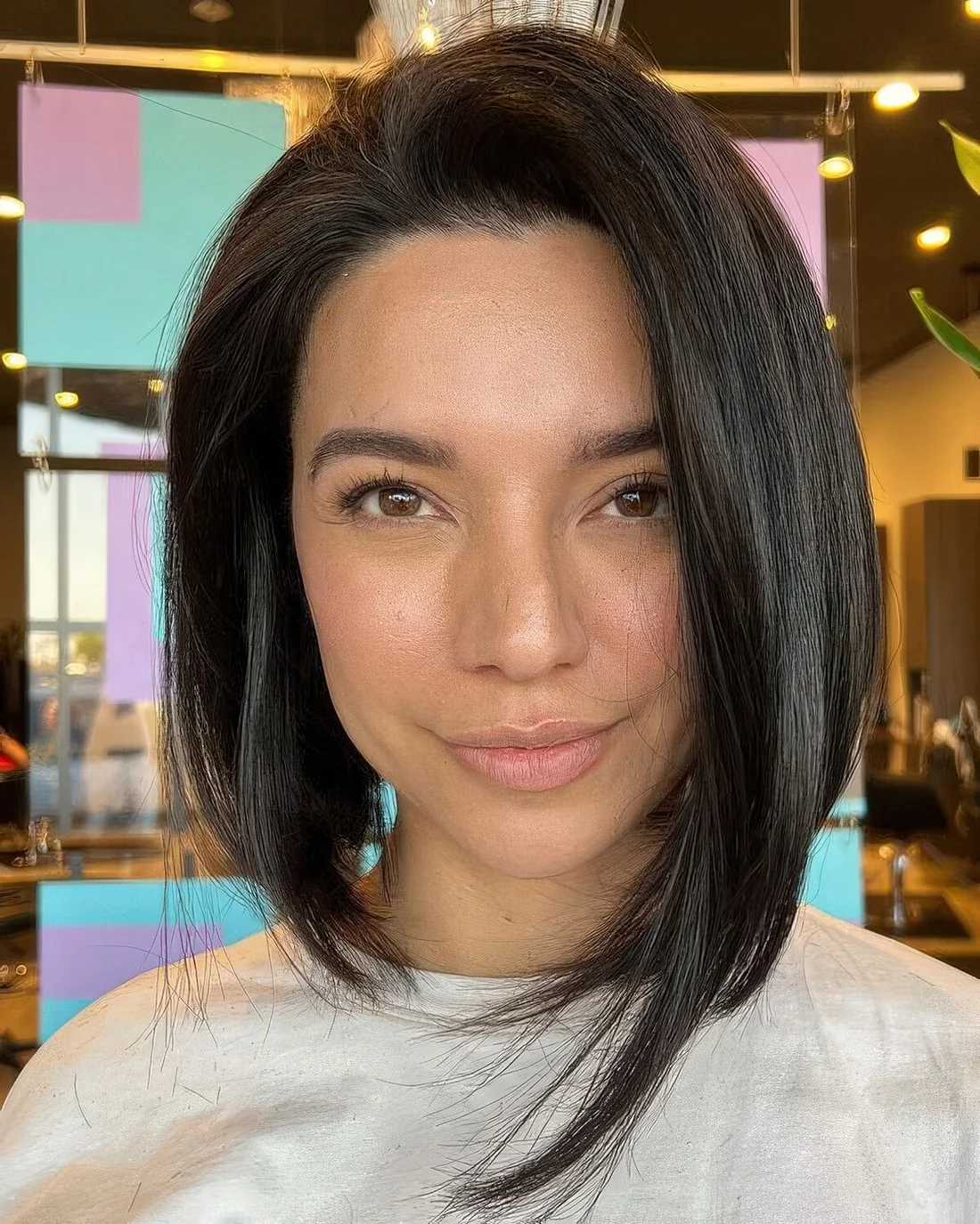 Black angled long bob with side part and a lot of volume.