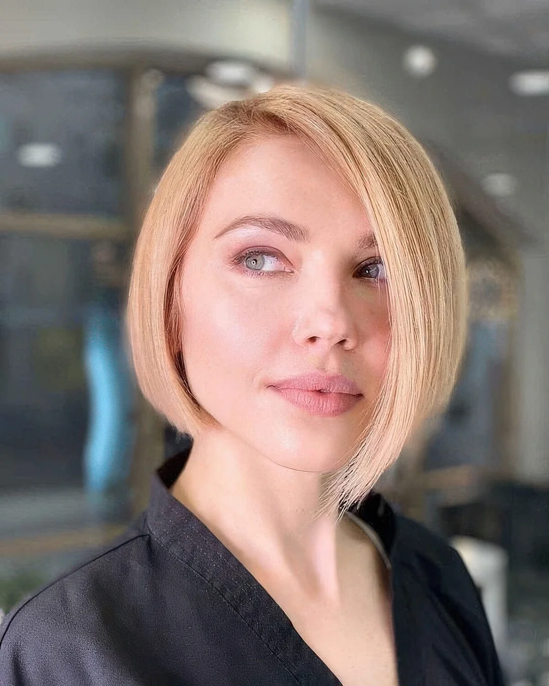 Blonde asymmetrical chin-length bob plus side part.